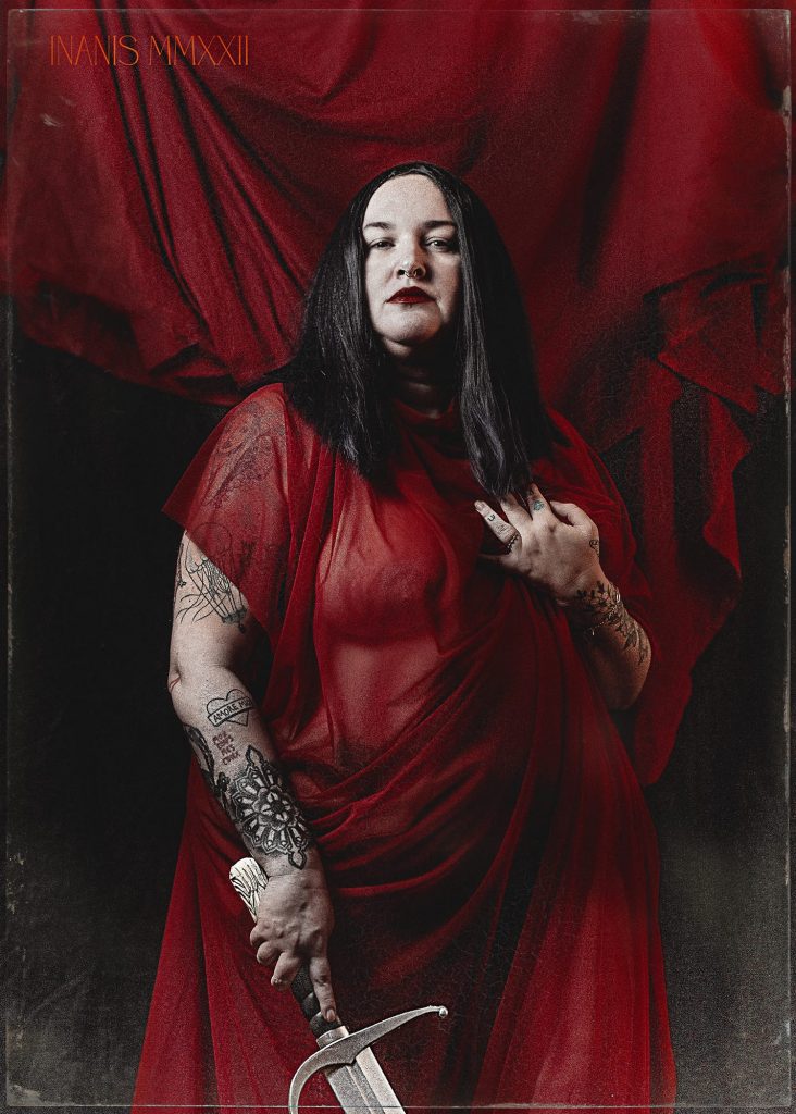 Rylee, posant pour un photographe dans une robe rouge transparente avec ses tatouages